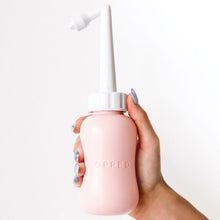 Load image into Gallery viewer, Woman holds pink Popped postpartum peri bottle upright