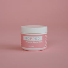 Load image into Gallery viewer, White cylindrical jar with pink label that reads: “Popped Organic Nipple Balm, 2 fl. oz.”
