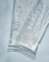 Load image into Gallery viewer, A two-count of hot and cold packs with clear, eco-friendly gel inside. They are both labeled with the brand name Popped, and they are on a light blue background.
