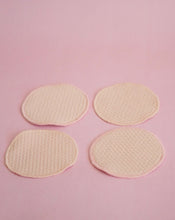 Load image into Gallery viewer, four breast pads lined up in a 2 by 2 formation on a pink background
