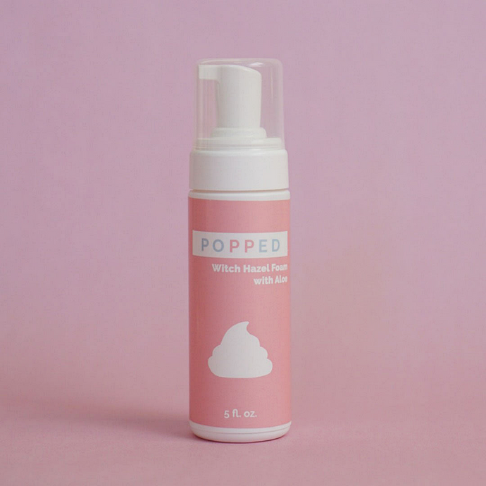 Tall white cylindrical bottle with pump/cap and a pink label reading: “Popped Witch Hazel Foam with Aloe, 5 fl oz.” There is also an icon of the foam on the label.