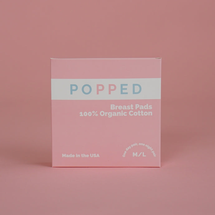 Square pink box that reads “Popped.  Breast Pads.  100% Organic Cotton. Made in the USA.”
